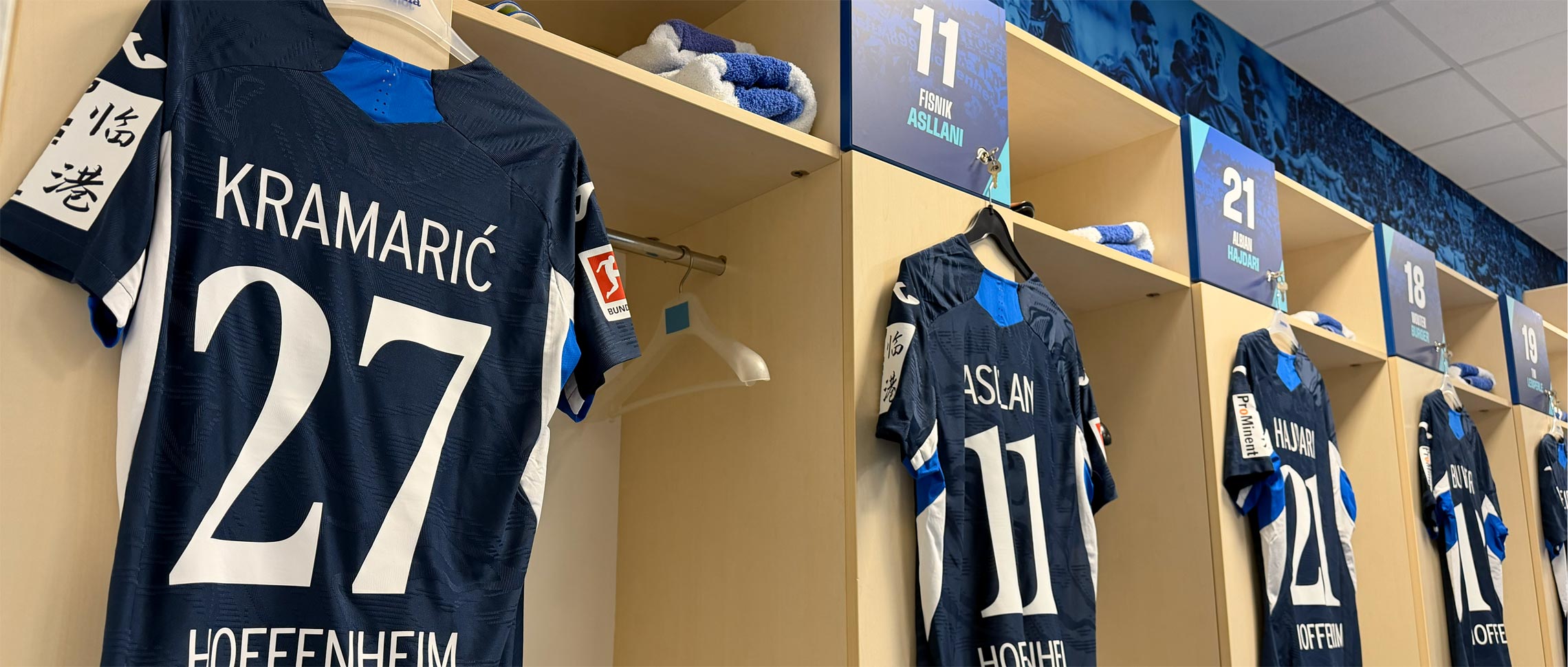 TSG Hoffenheim starting lineup graphic displayed on a large screen before a match against Bayer Leverkusen on the pitch.